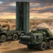 A Russian S-500 Prometheus air defense system conducting a missile test launch in a desert environment during sunset.