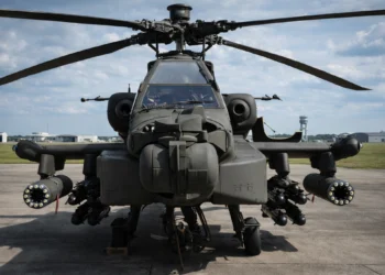 Front view of a US Army AH-64E Apache Guardian attack helicopter armed with Hellfire missiles and 30mm cannon, featuring the mast-mounted Longbow radar.